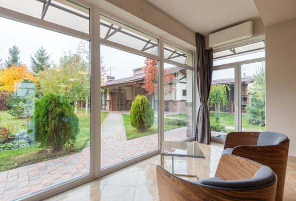 Impeccable glass windows and sliding doors facing the garden of a modern luxury villa